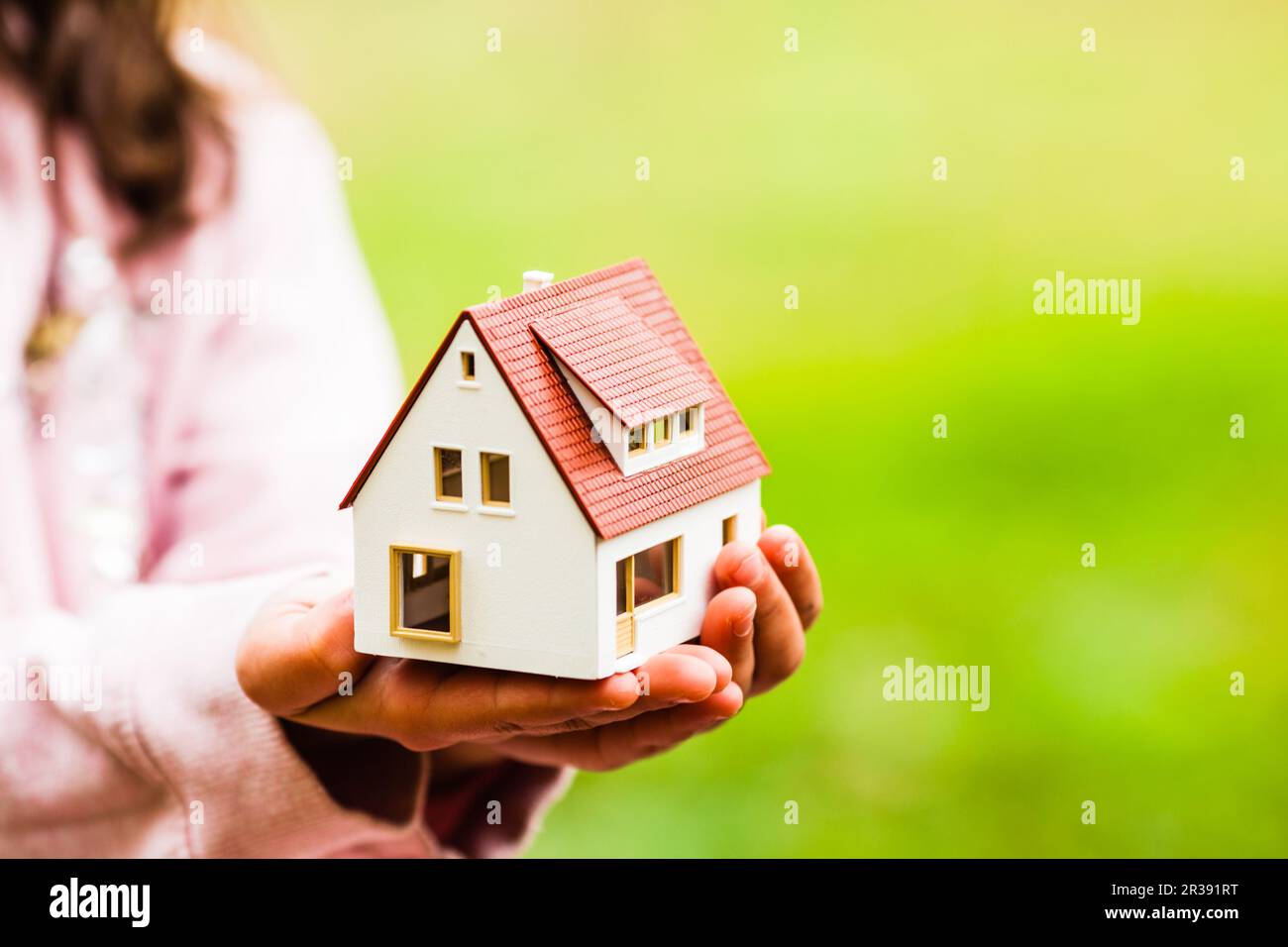 Casa per ogni bambino, piccolo giocattolo nelle mani Foto Stock