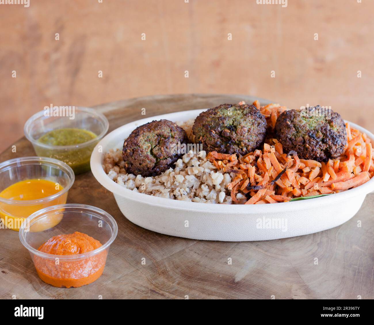 Una terrina di falafel con verdure e un trio di salse Foto Stock