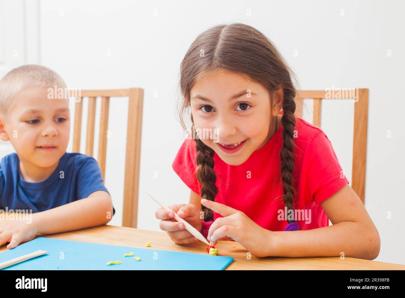 Fratello e sorella che si divertono insieme a modellare l'argilla Foto Stock