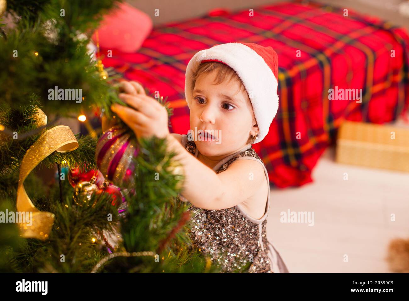 Piccola figlia decora soggiorno per Natale. Foto Stock
