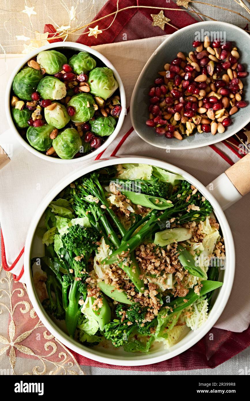 Cavoli di Bruxelles, cavolo di savoia e broccoli con semi di melograno e noci per Natale Foto Stock
