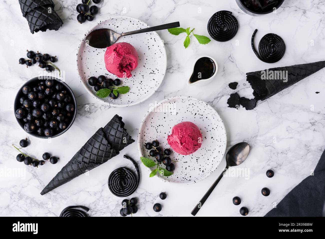 Gelato alla liquirizia con ribes neri su piatti da dessert bianchi Foto  stock - Alamy