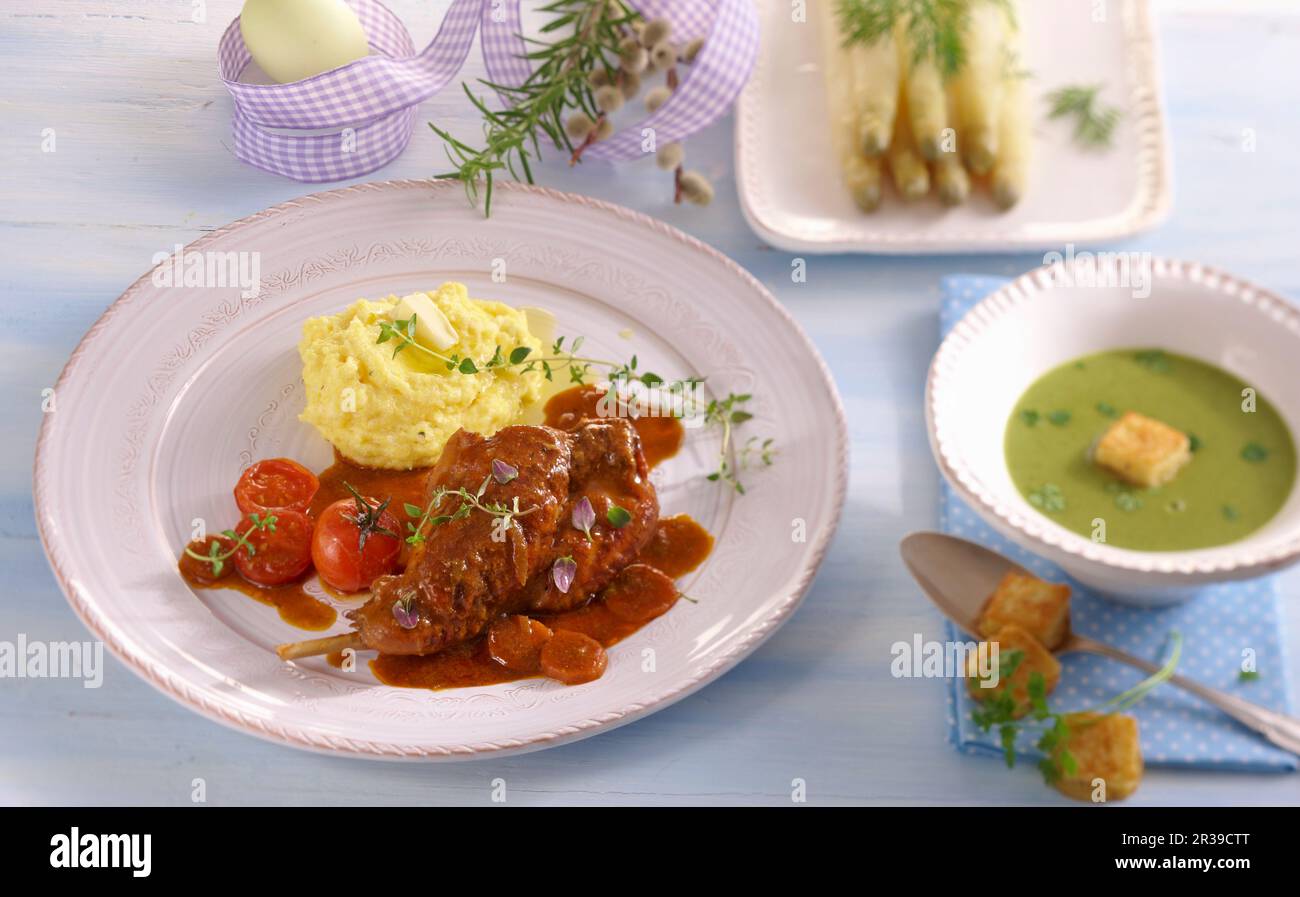 Un menu pasquale con zuppa di cervi, cosce di coniglio con purè di patate e asparagi Foto Stock
