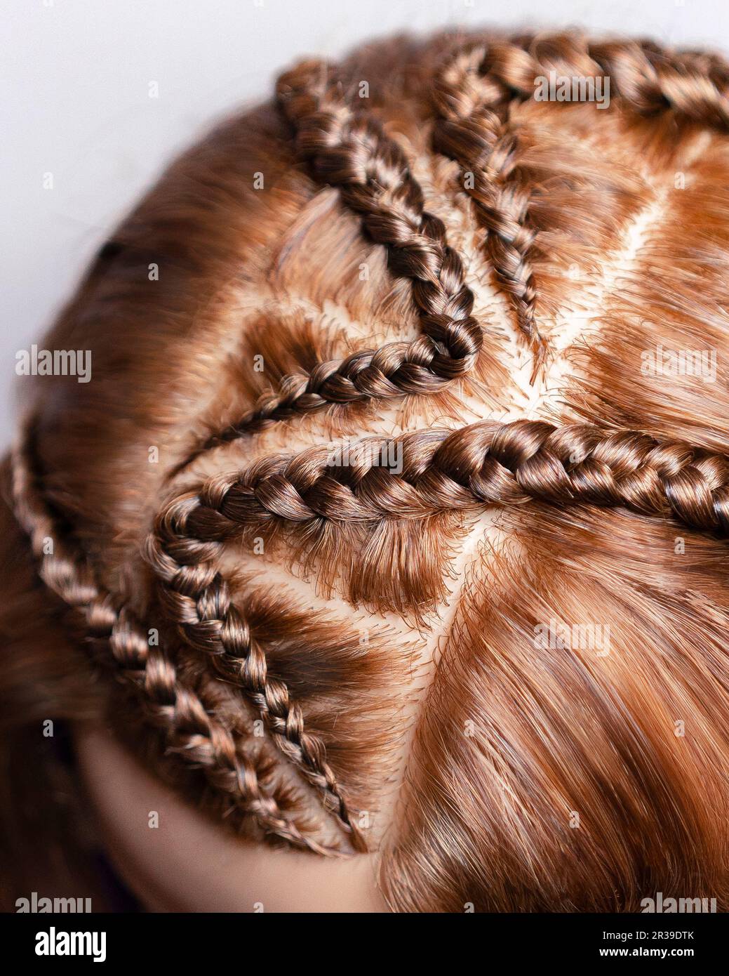 Disegni fatti di capelli, tessitura delle trecce, primo piano di fondo dei capelli Foto Stock