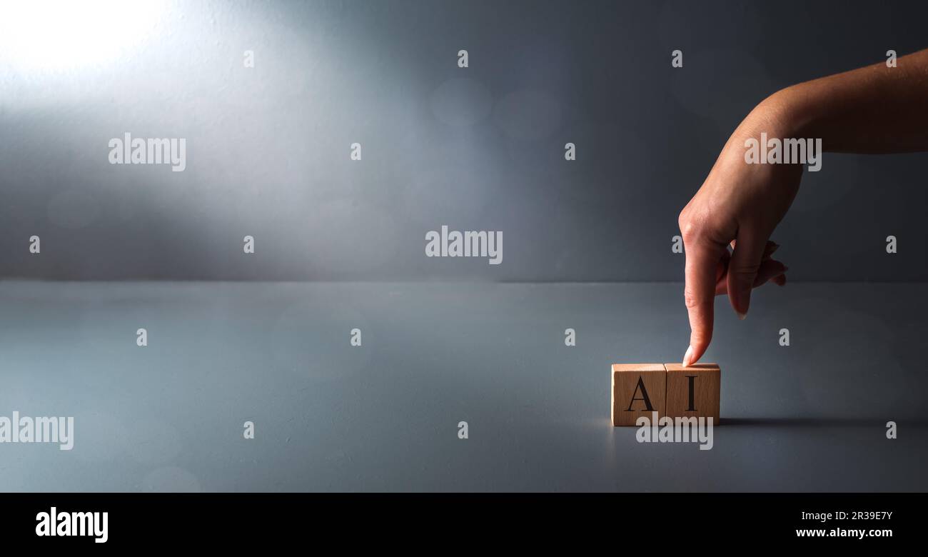 Concetto di ai sul posto di lavoro, assistente virtuale, mano posando blocco di legno su sfondo grigio. Foto Stock