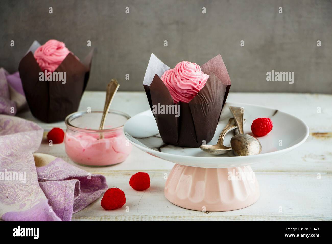 Deliziose tortine di glassa decorata con rosa di crema di formaggio e lampone Foto Stock