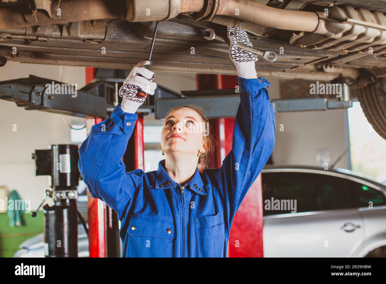 Donna meccanico controlla la sospensione della vettura Foto Stock