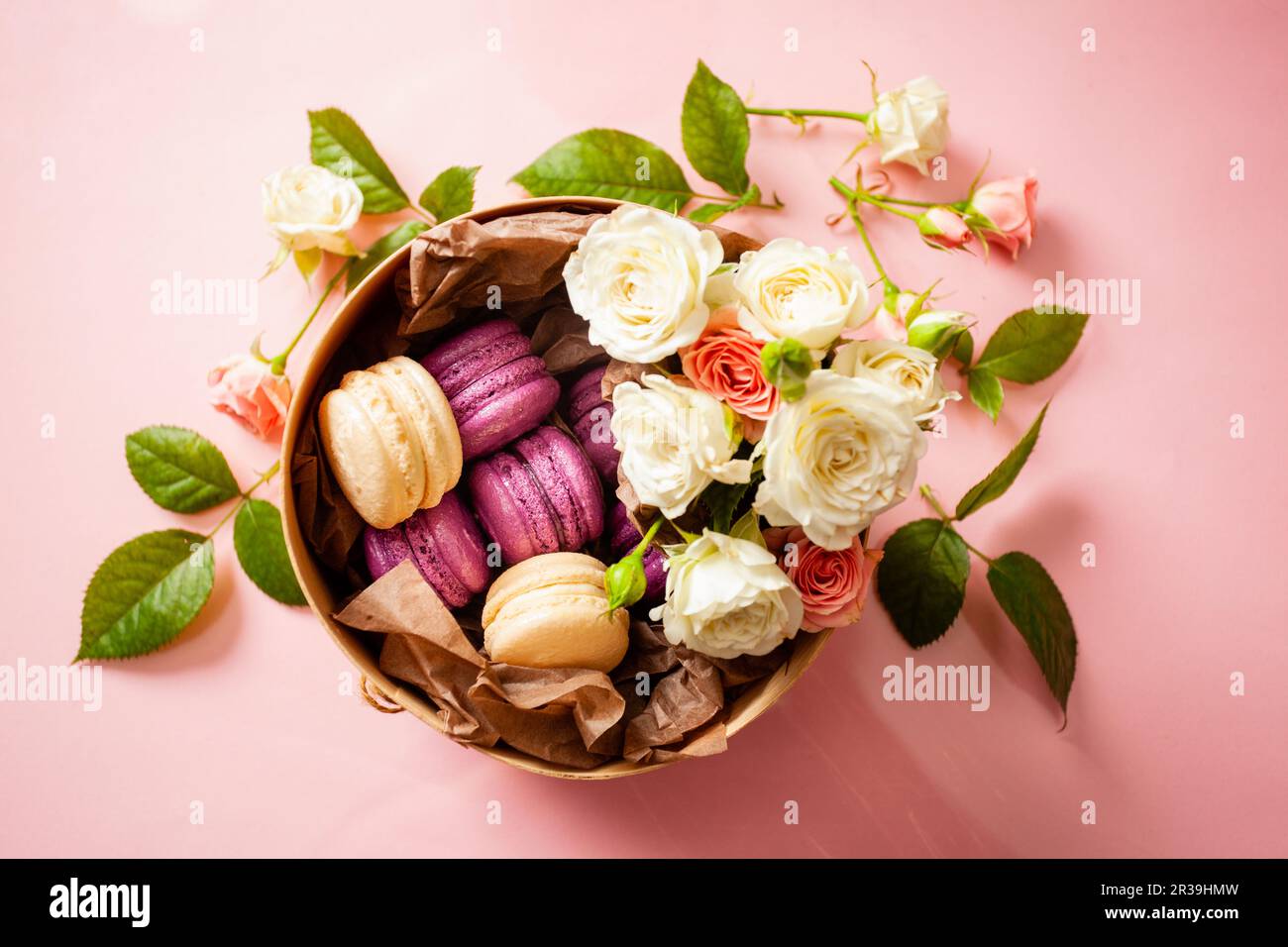 Scatola con deliziosi amaretti luminosi e fiori Foto Stock