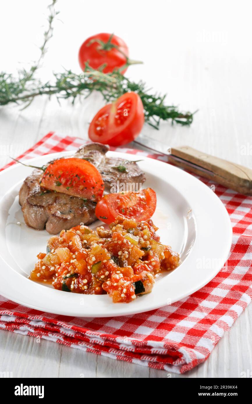 Colli di maiale con quinoa e chutney di pomodoro Foto Stock