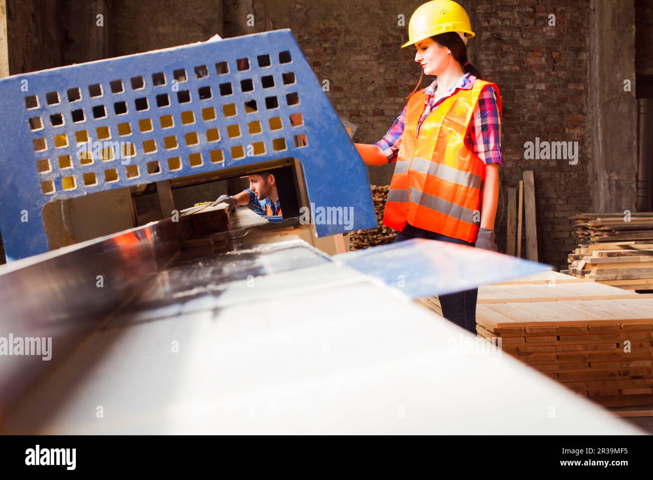 Donna di lavoro in casco protettivo in laboratorio di lavorazione del legno. Concetto di uguaglianza di genere. Foto Stock