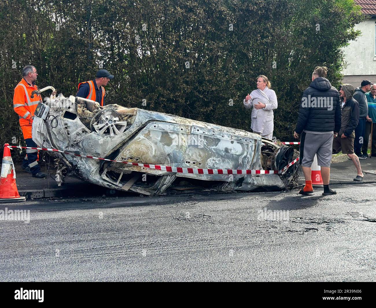 I lavoratori del consiglio si assicurano la zona immediatamente intorno ad un'automobile che è stata messa in luce a Ely, Cardiff, dopo la rivolta che scoppiò dopo che due adolescenti sono morti in un incidente. Le tensioni raggiunsero il punto di rottura dopo che gli ufficiali furono chiamati alla collisione, in Snowden Road, Ely, alle 6pm di lunedì circa. Gli ufficiali affrontarono quello che chiamavano "disordine su larga scala”, con almeno due auto torchiate come problemi che coinvolgevano decine di giovani arenati per ore. Data immagine: Martedì 23 maggio 2023. Foto Stock