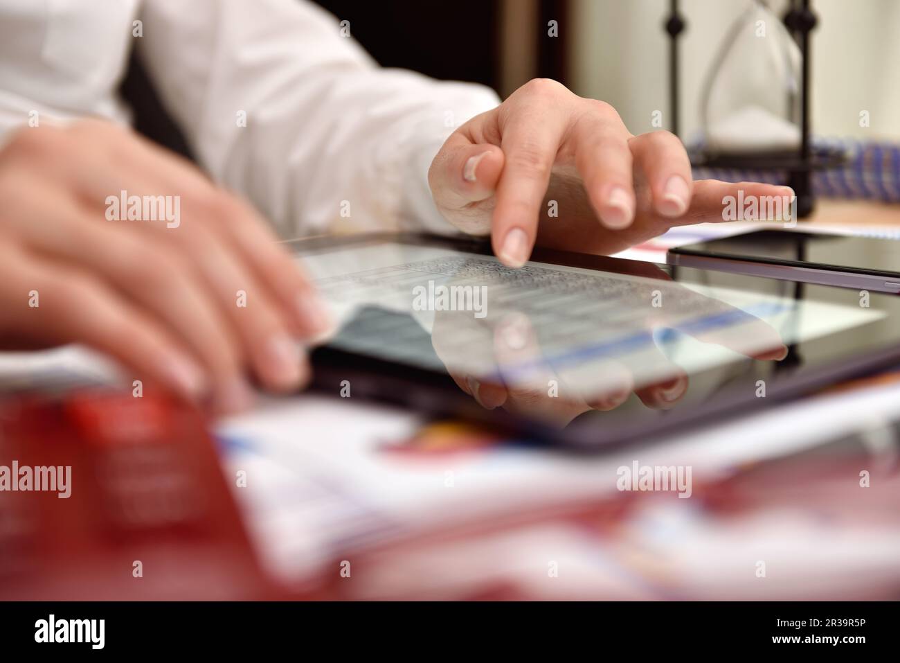 Mano donna che analizza i dati di reddito sullo schermo del tablet. Primo piano Foto Stock