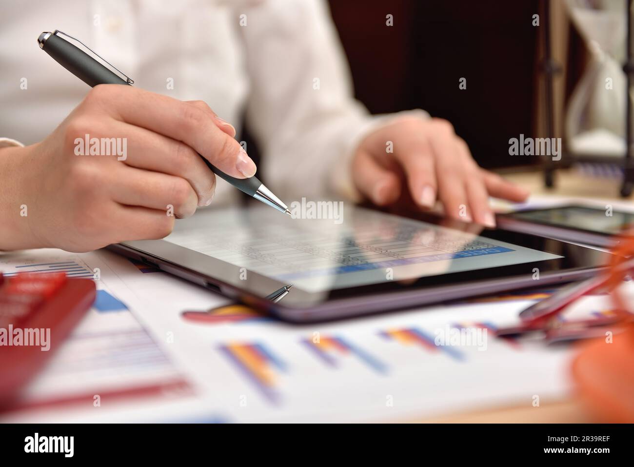 donna contabile che analizza i dati sul reddito e i grafici sullo schermo del tablet digitale. Primo piano Foto Stock