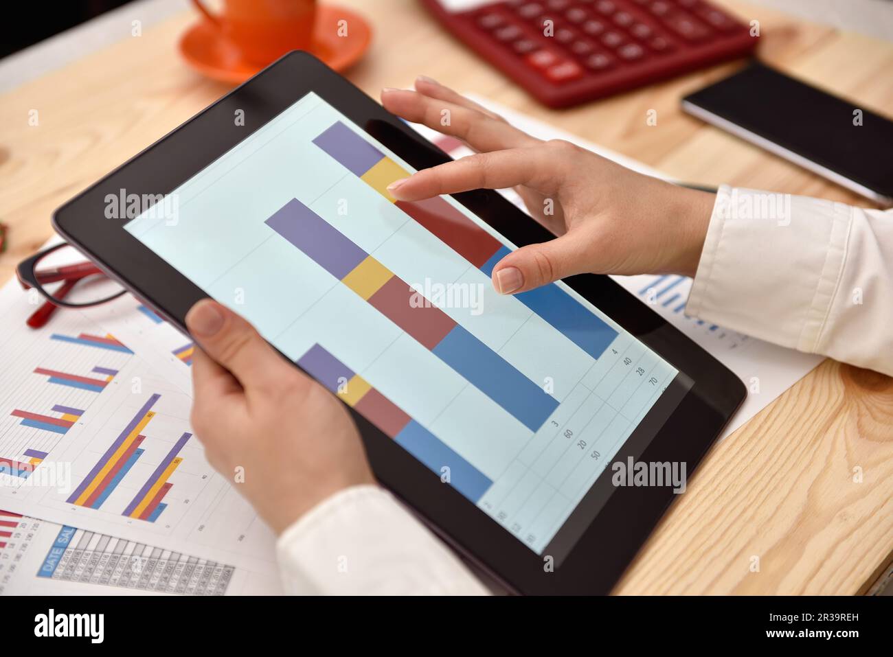 Donna che utilizza un tablet con dati finanziari sotto forma di grafici e diagrammi. Primo piano Foto Stock