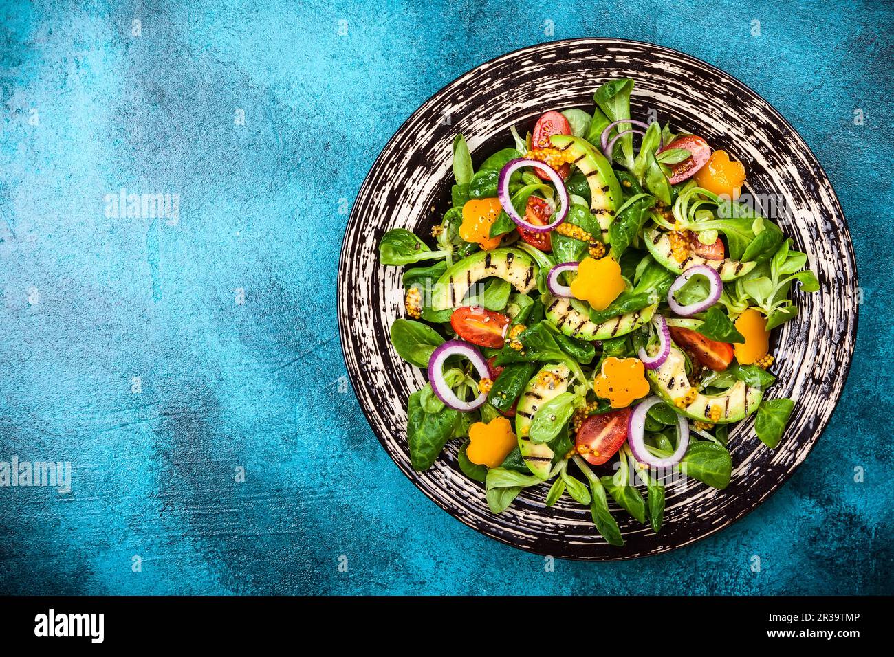 Per mangiare sano: Insalata con avocado alla griglia, verdure fresche e condimento di senape. Vista dall'alto Foto Stock