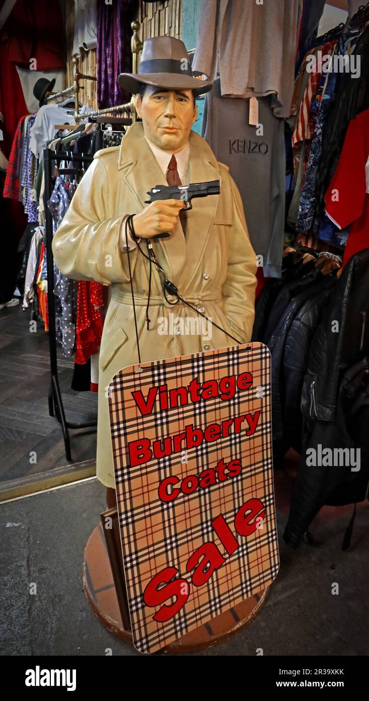 Modello in stile Humphrey Bogart con un cartello che pubblicizza una "vendita di Burberry d'epoca" all'interno di un chiosco al Brick Lane Vintage Market nella zona est di Londra Foto Stock