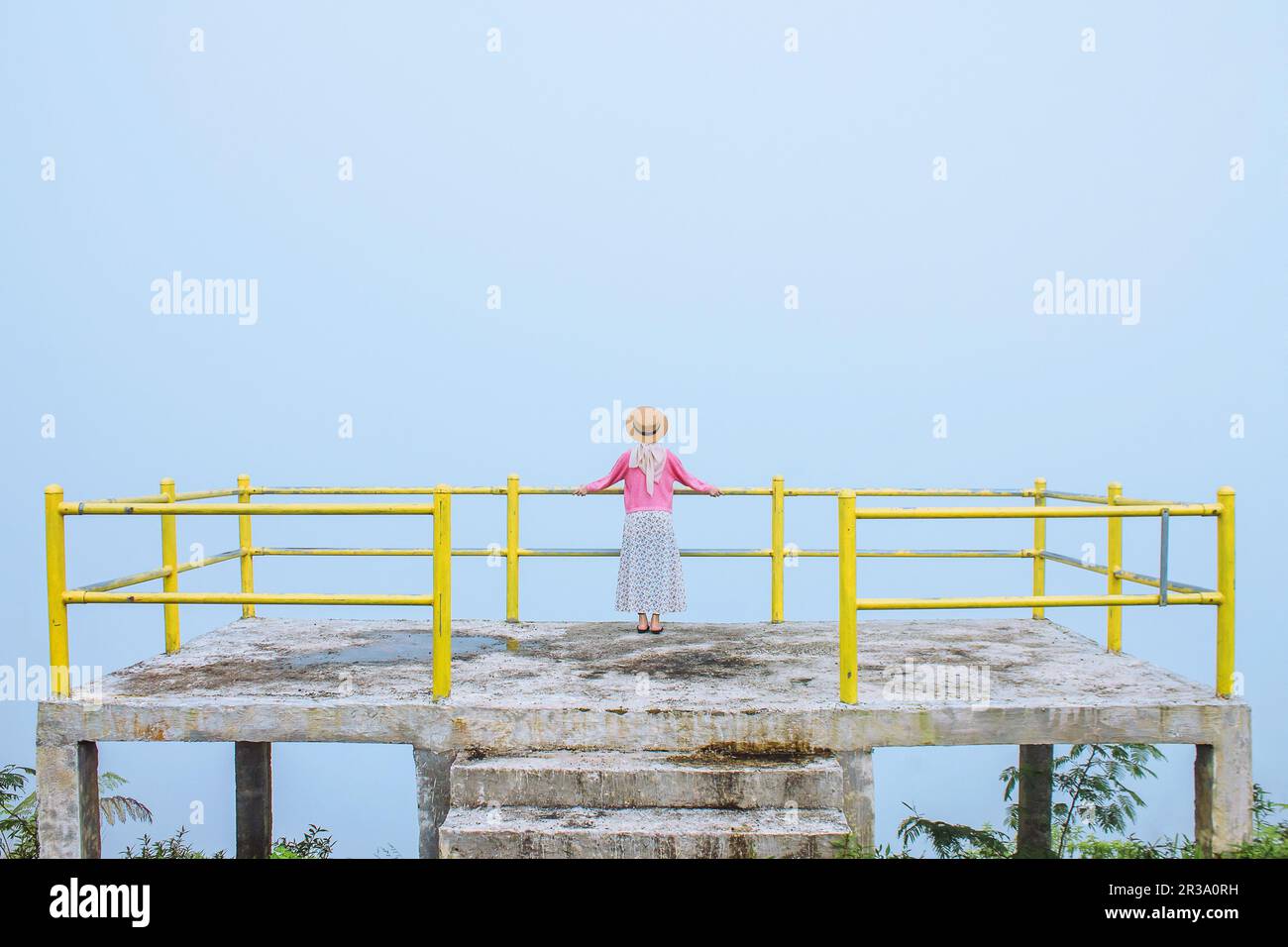 Un viaggiatore femminile si siede godendo la bellezza della natura dall'alto delle montagne Foto Stock