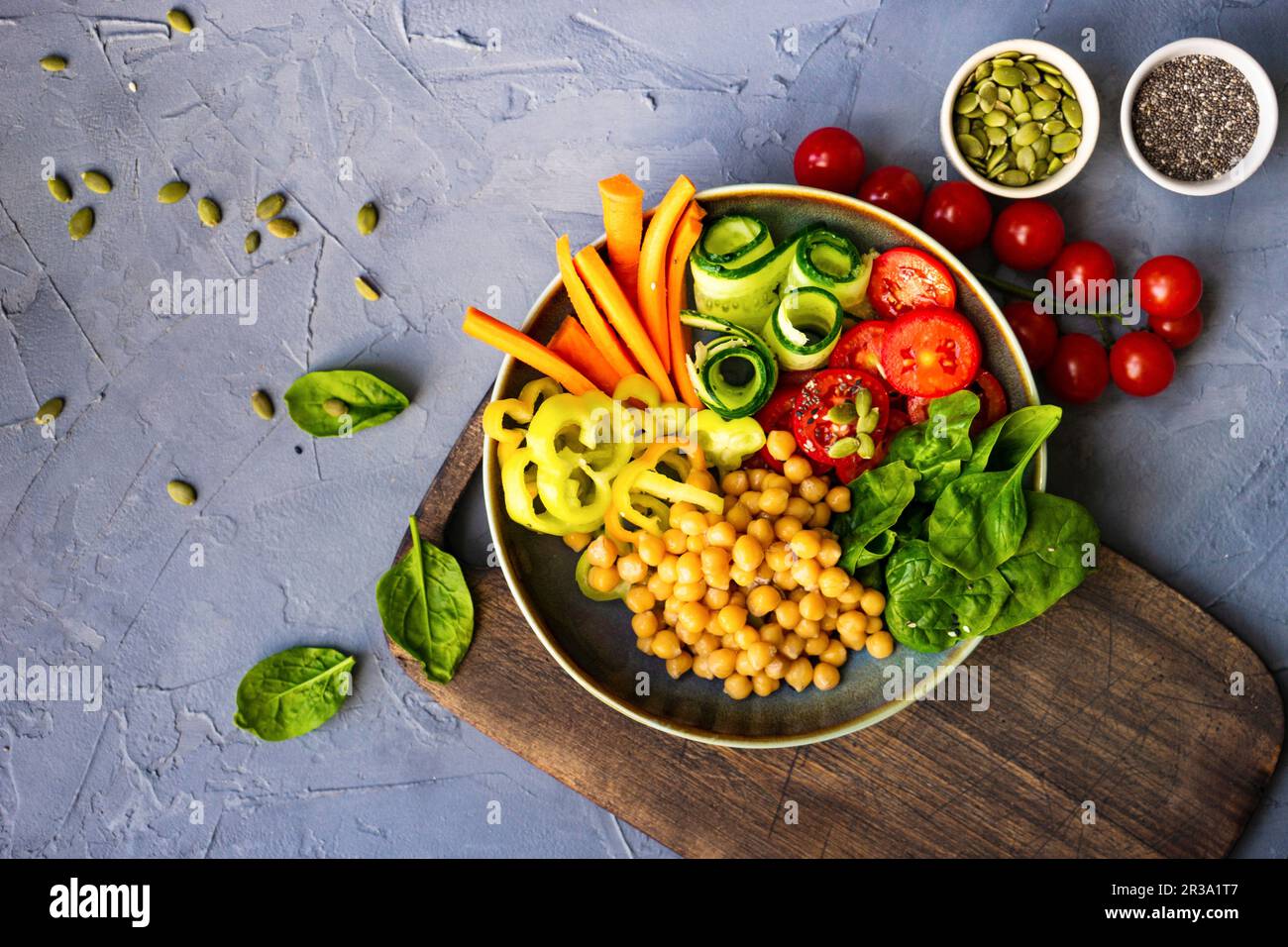Ciotola di Buddha con ceci, spinaci e altre verdure organiche su fondo di cemento Foto Stock