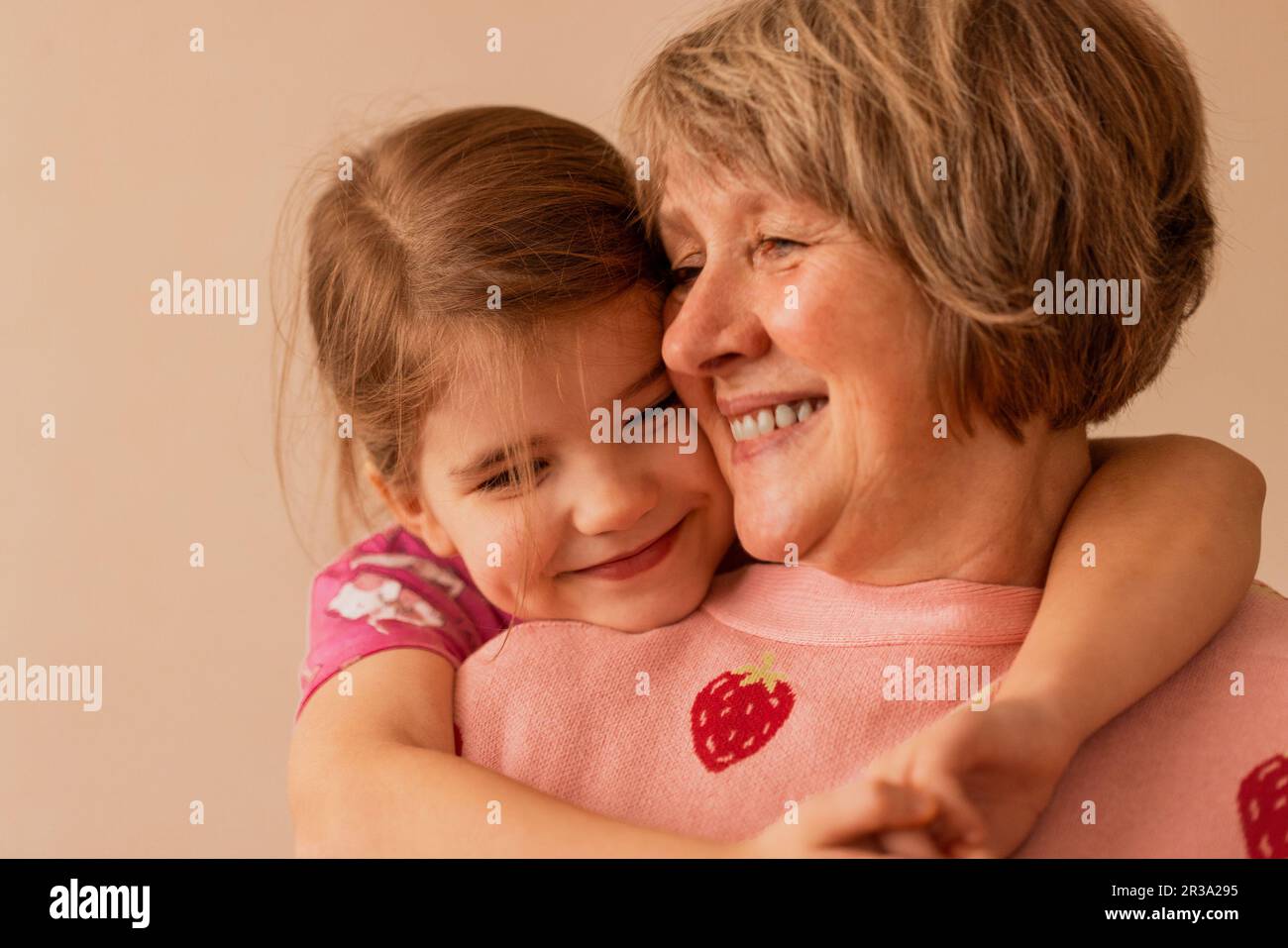 Primo piano ritratto di carina nipote che abbraccia la sua bella nonna, godendo il tempo libero insieme. Bionda bella ragazza coccole fino a smi Foto Stock
