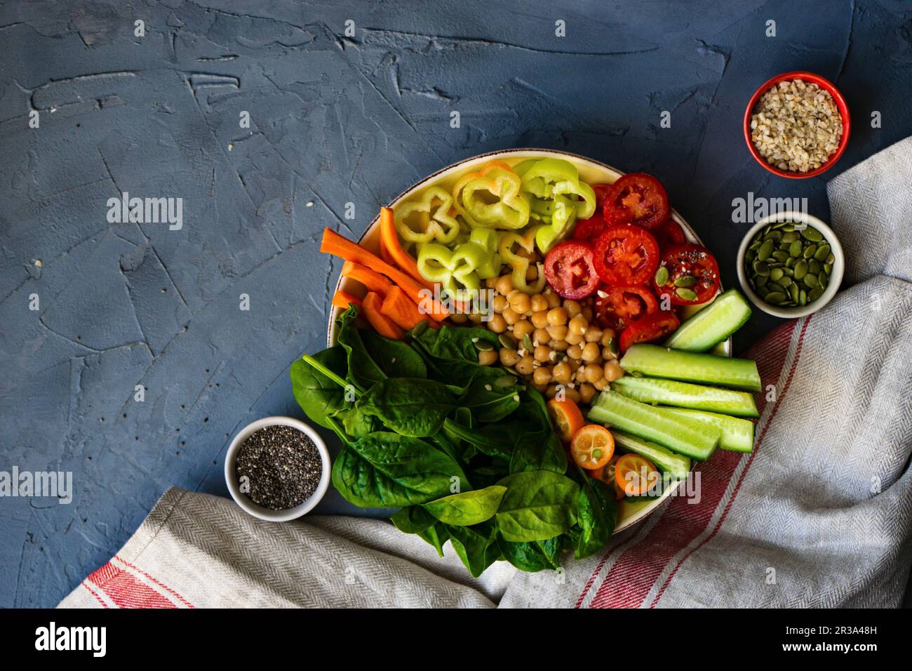 Ciotola di Buddha con ceci, spinaci e altre verdure organiche su fondo di cemento Foto Stock