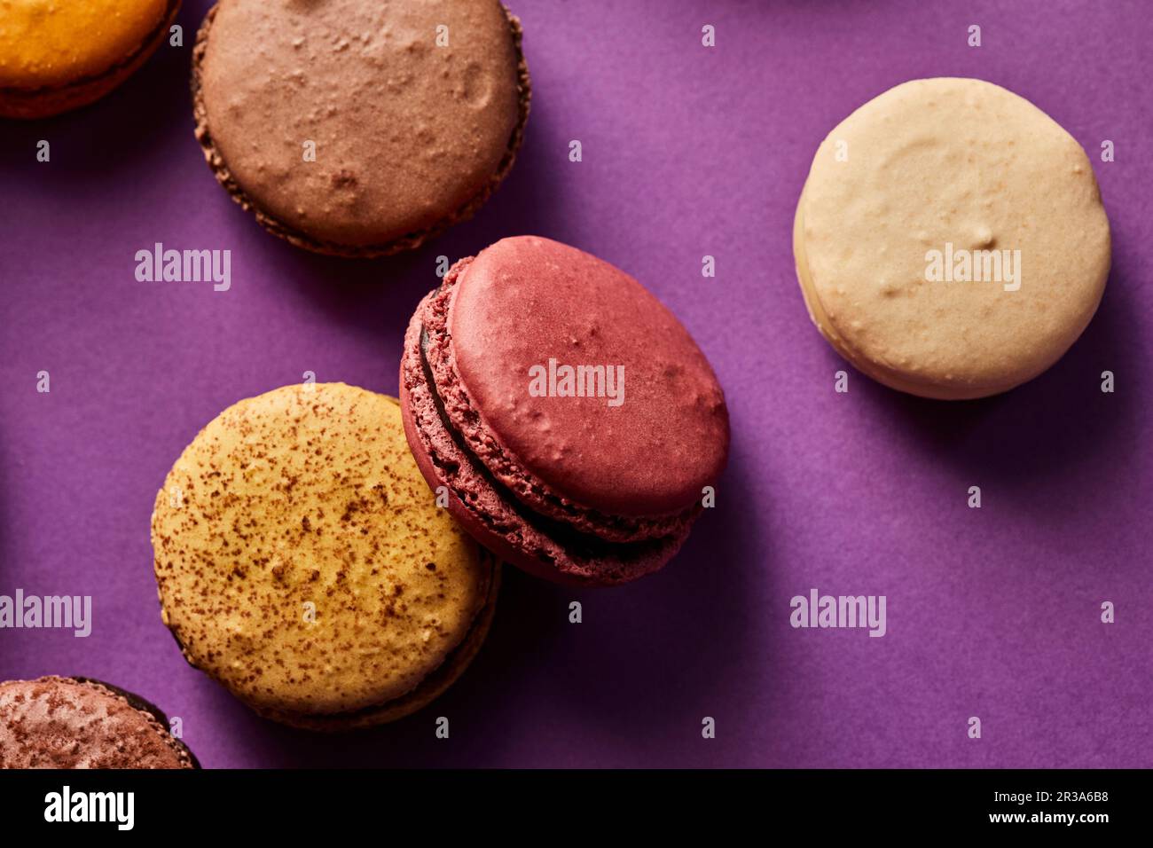 Assortimento di macaron colorati su sfondo viola Foto Stock