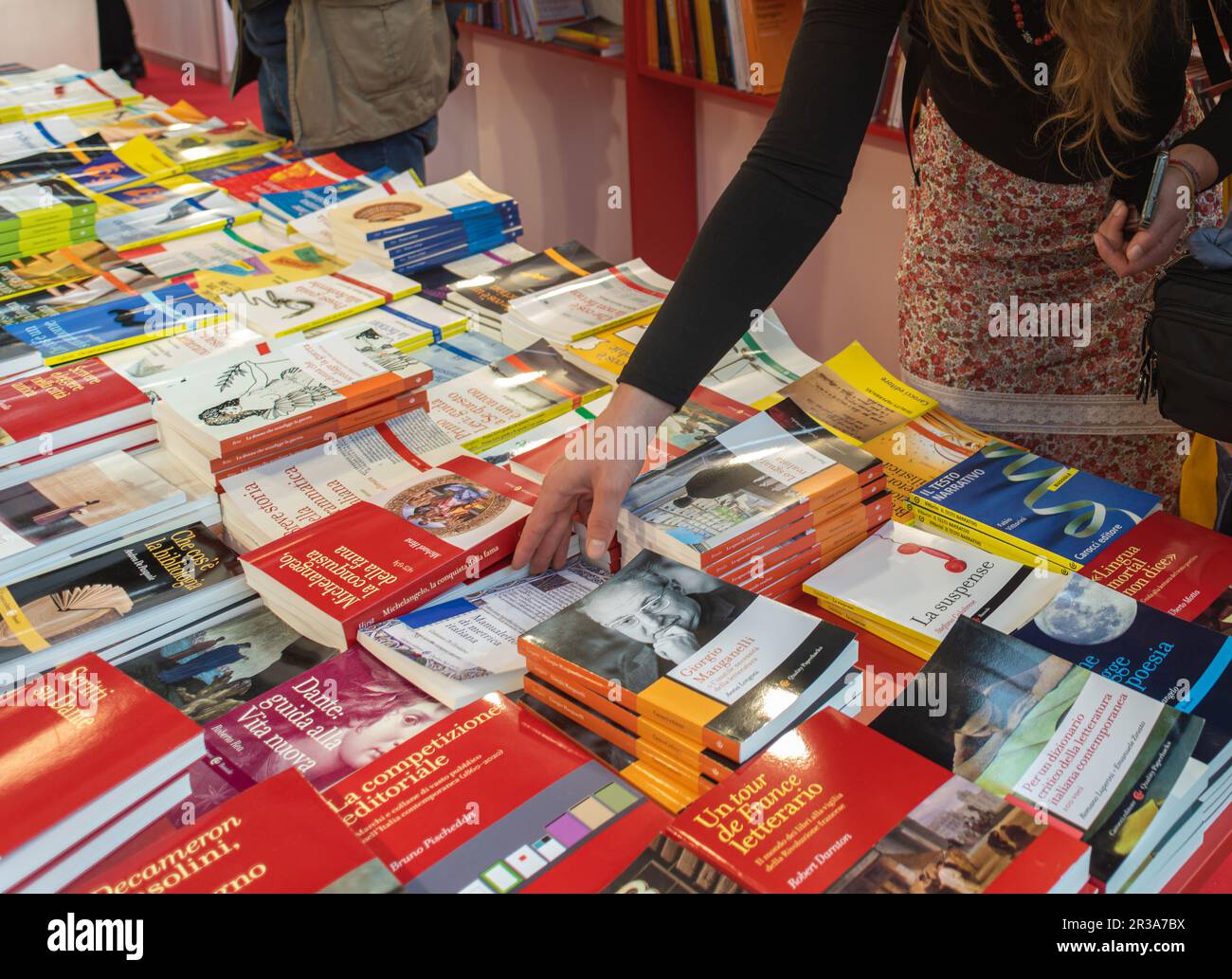 Torino, Italia - 2023 maggio 22: Mano di ragazza che sceglie libri che vengono esposti nello stand degli editori del Salone Internazionale del Libro di Torin Foto Stock