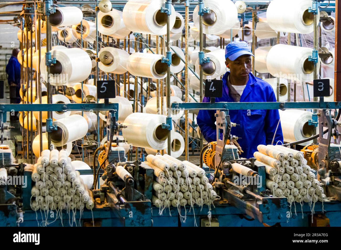 Lavoratore di fabbrica africano su un telaio di catena di montaggio di trama di copwinder Foto Stock