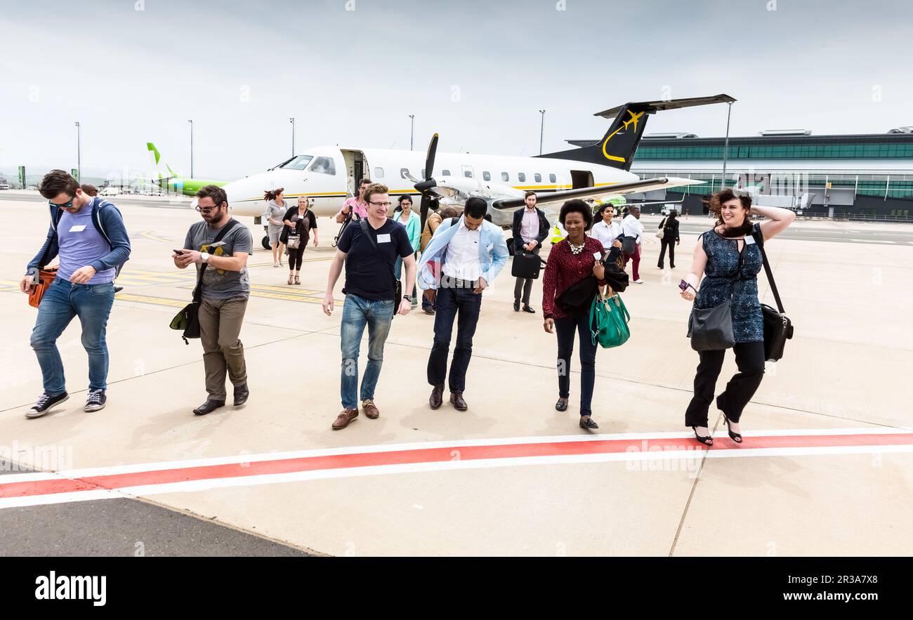 Passeggeri che sbarcano un piccolo aereo charter a motore ad elica all'aeroporto locale Foto Stock