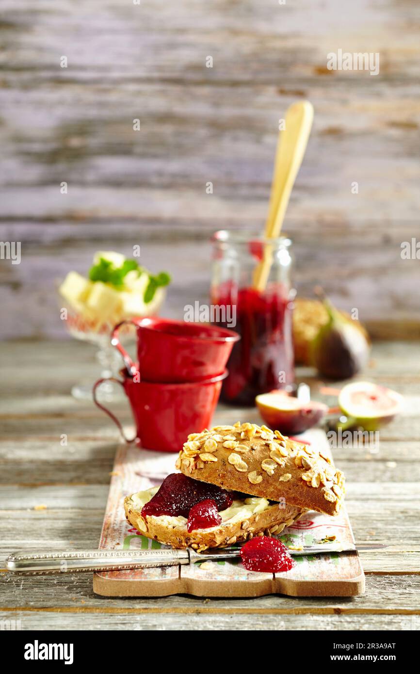 Confettura di amarene e fichi su pane integrale con burro Foto Stock