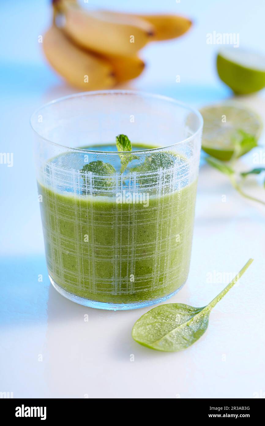 Un frullato verde a base di banana, mela, spinaci, cetriolo, zenzero, latte di lime e cocco Foto Stock
