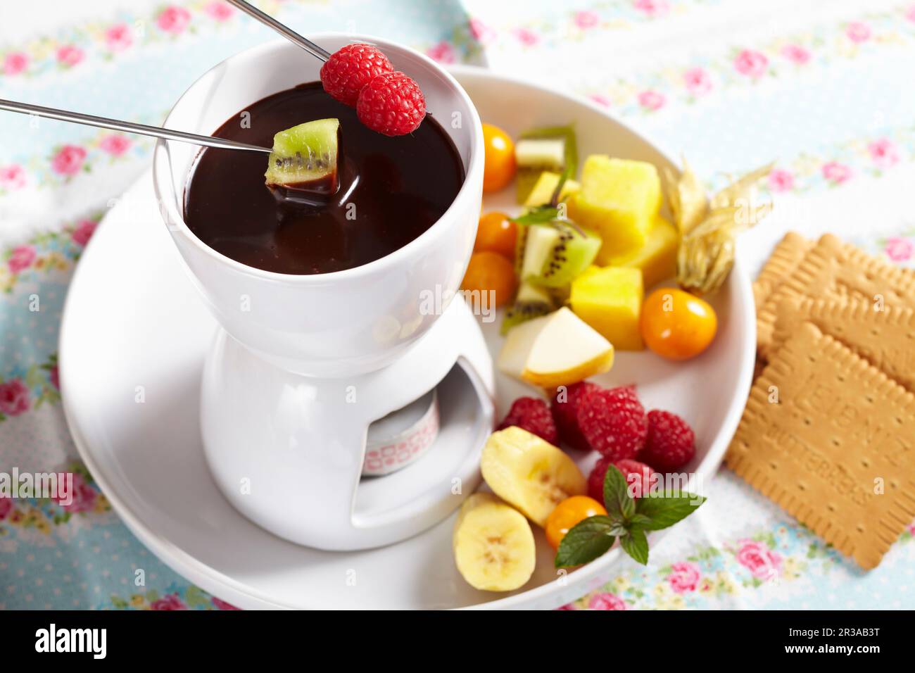 Una piccola fonduta di cioccolato per dessert con frutta fresca e biscotti Foto Stock