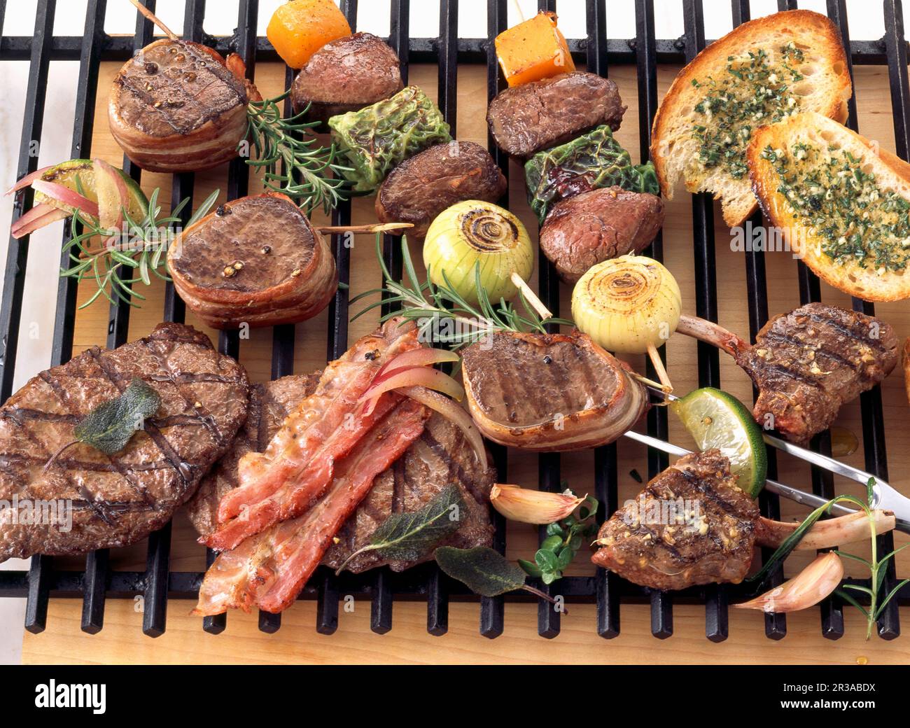 Varie carni di selvaggina e verdure su una griglia rack Foto Stock