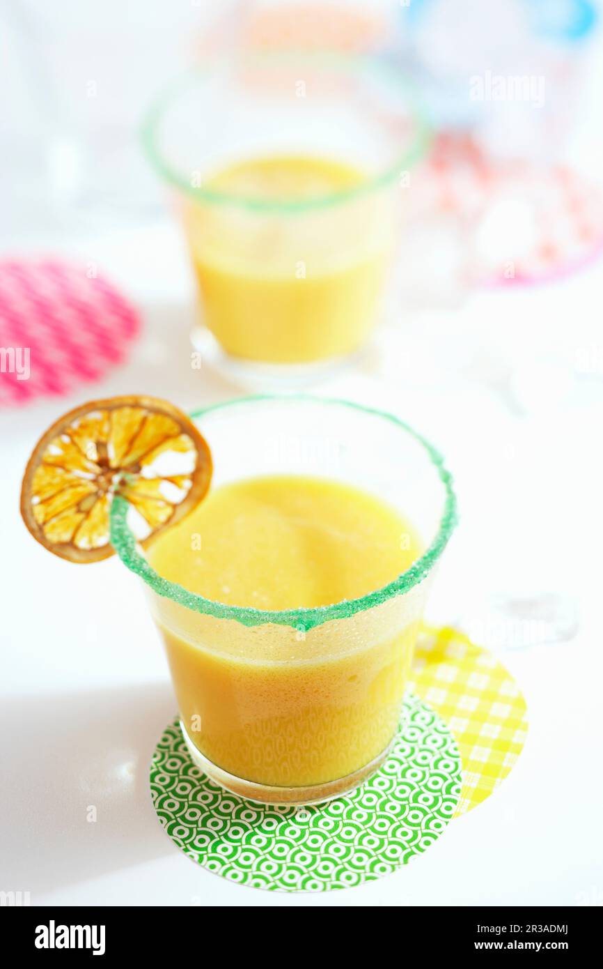 Frappé di papaya con banana decorata con una fetta secca di arancia Foto Stock