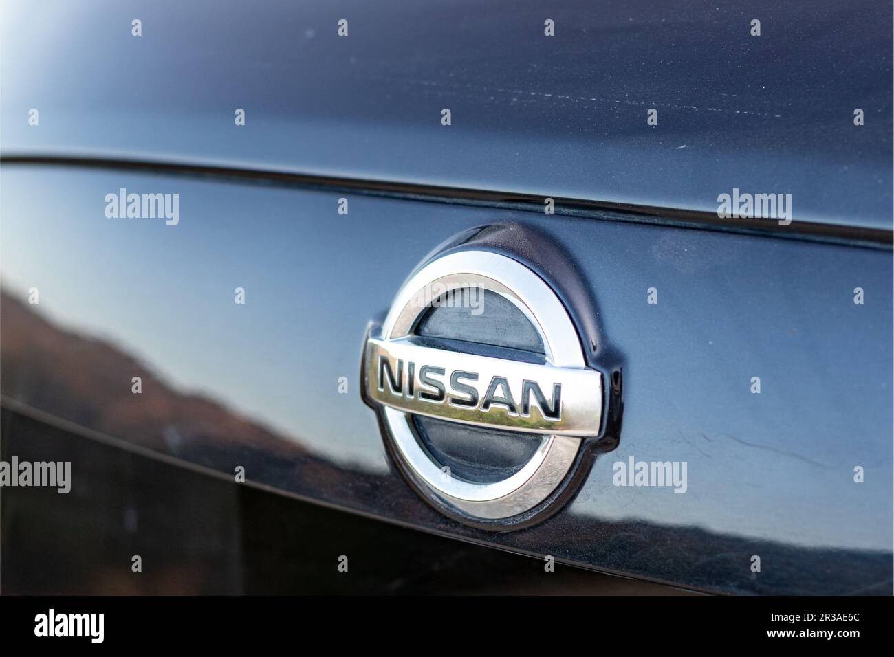 Logo Nissan auto montato sul retro di un crossover con messa a fuoco selettiva Foto Stock