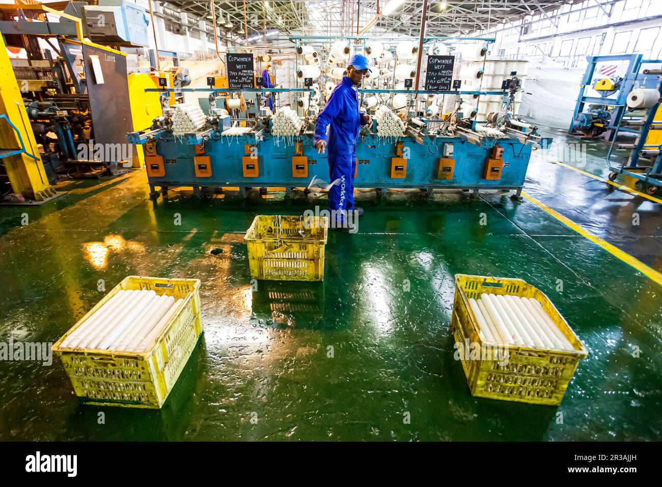 Lavoratore di fabbrica africano su un telaio di catena di montaggio di trama di copwinder Foto Stock