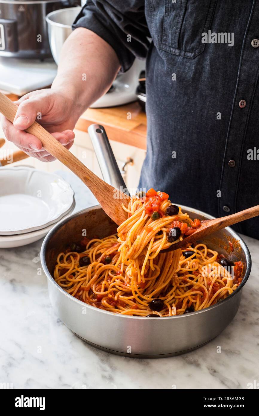 Uomo con puttanesca di pasta Foto Stock