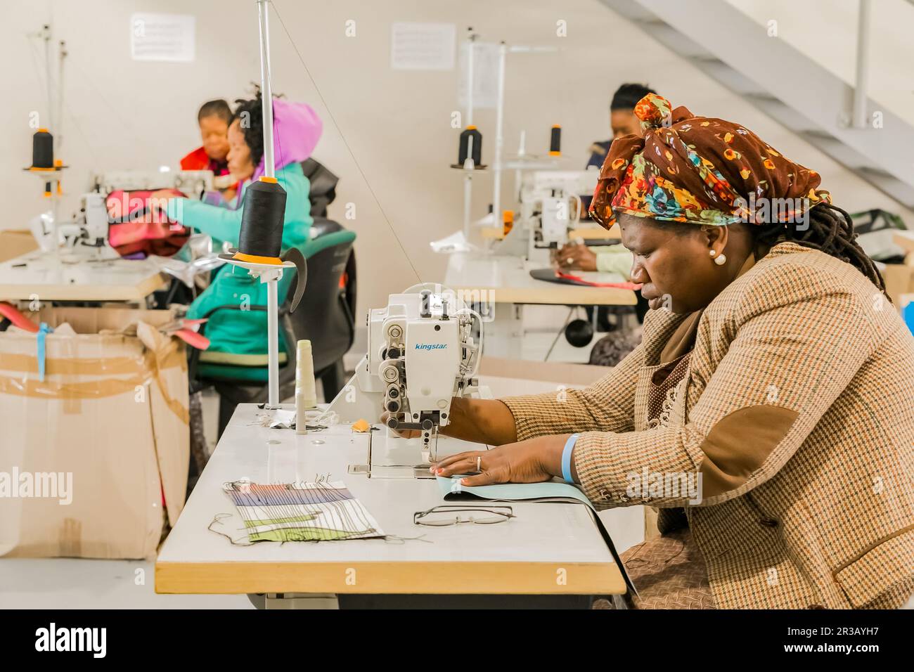 Donne africane che lavorano su indumenti fatti a mano utilizzando una macchina da cucire Foto Stock