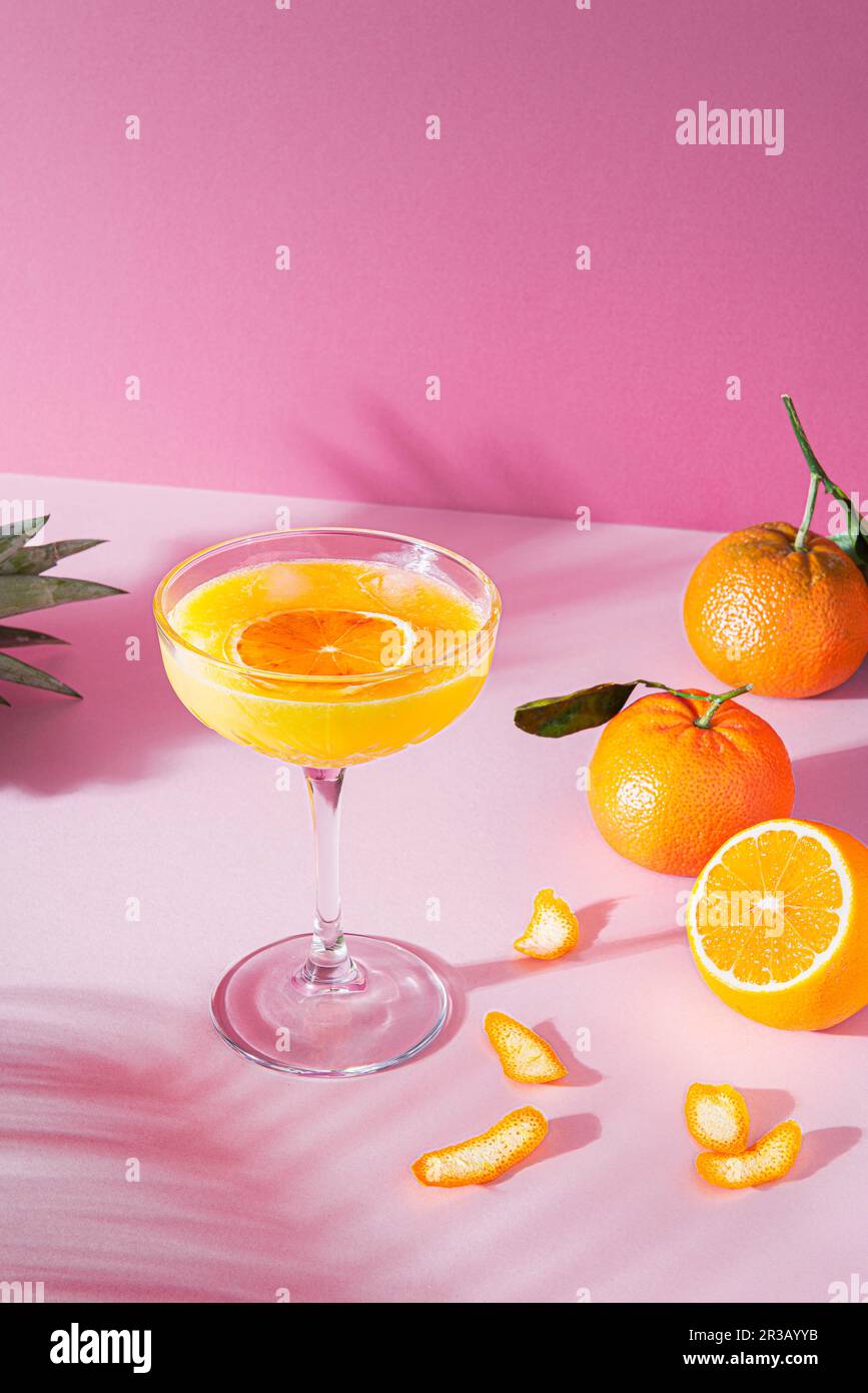 Cocktail all'arancia in un bicchiere a stelo alto Foto Stock