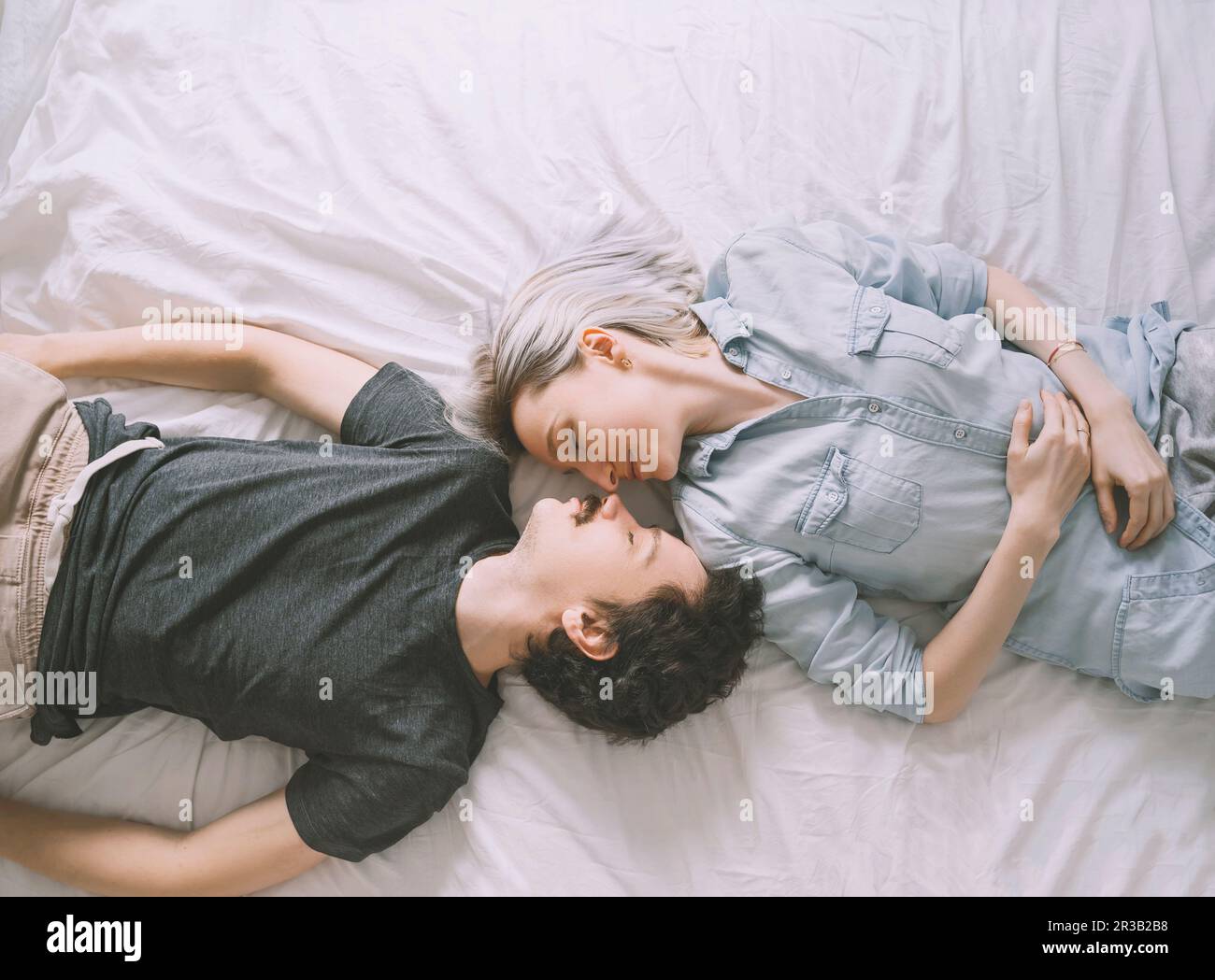 Amare giovane sdraiato sul letto di casa Foto Stock