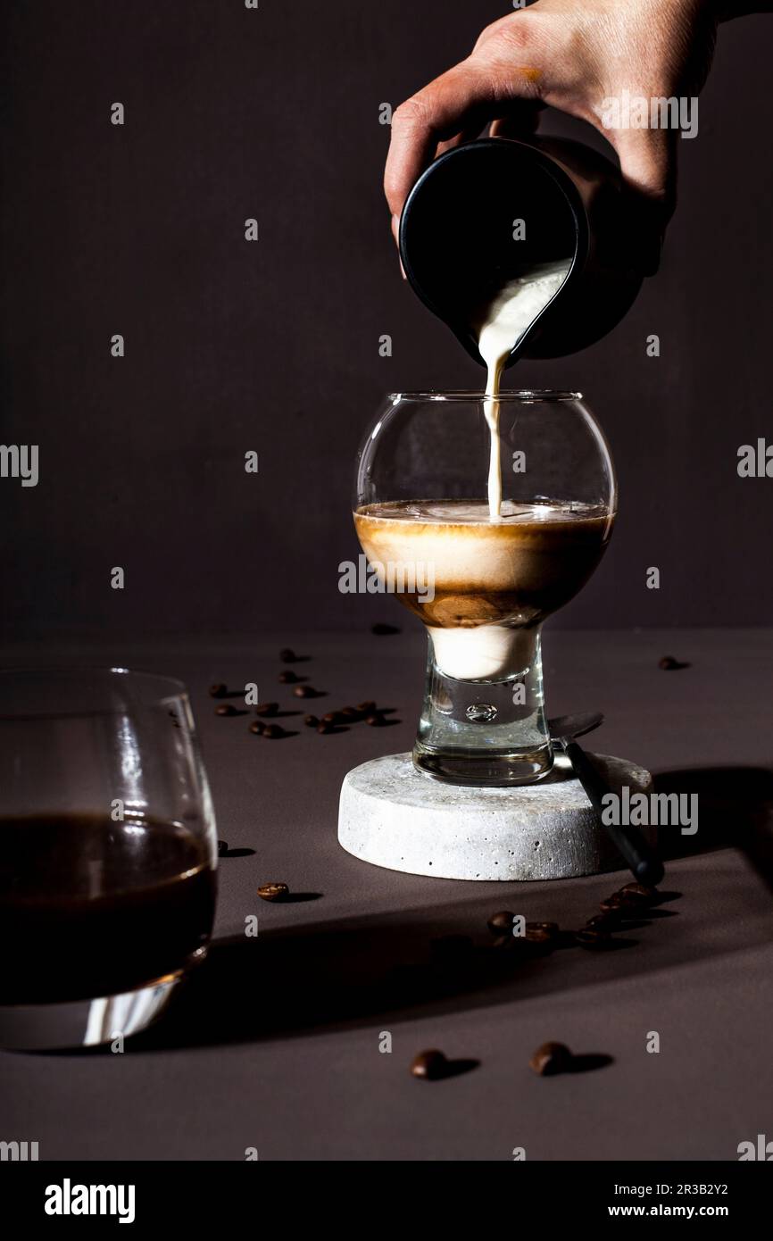 Una bevanda a base di caffè in un bicchiere con latte Foto Stock