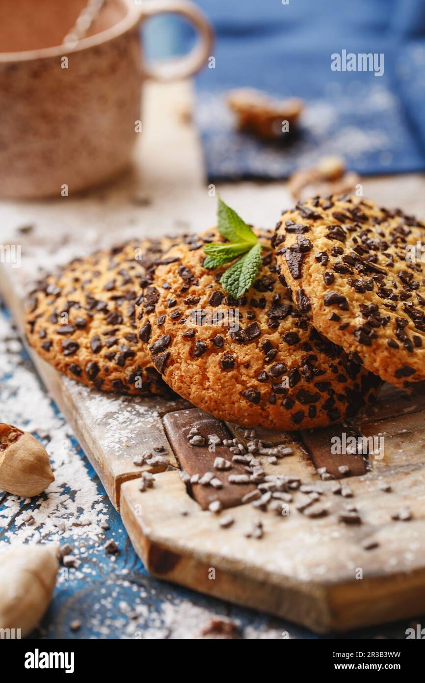 Biscotti con scaglie di cioccolato sulla tavola di legno. Mystic Light fotografia alimentare. Foto Stock