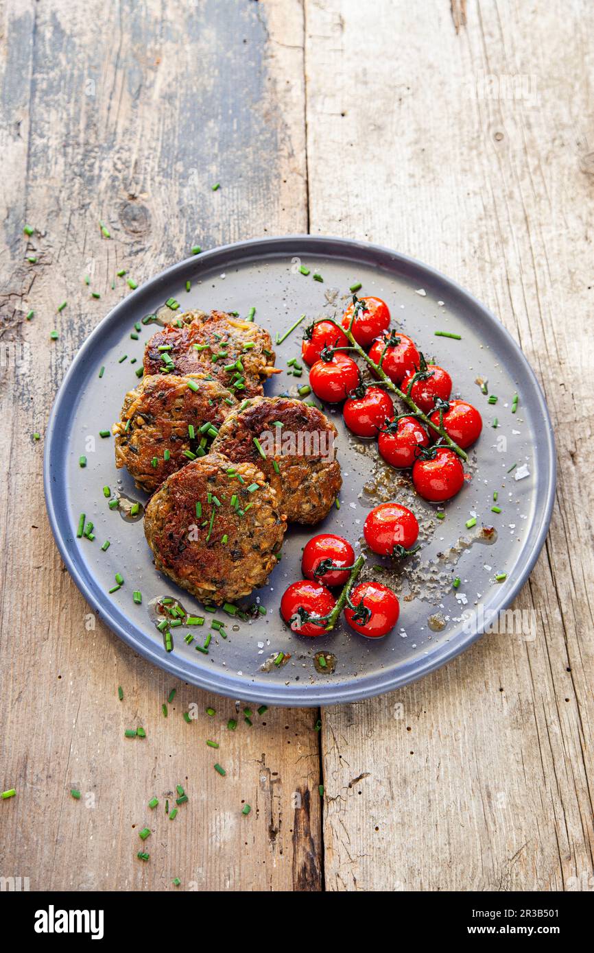 Frittelle di pastinaca con pomodori ciliegini Foto Stock