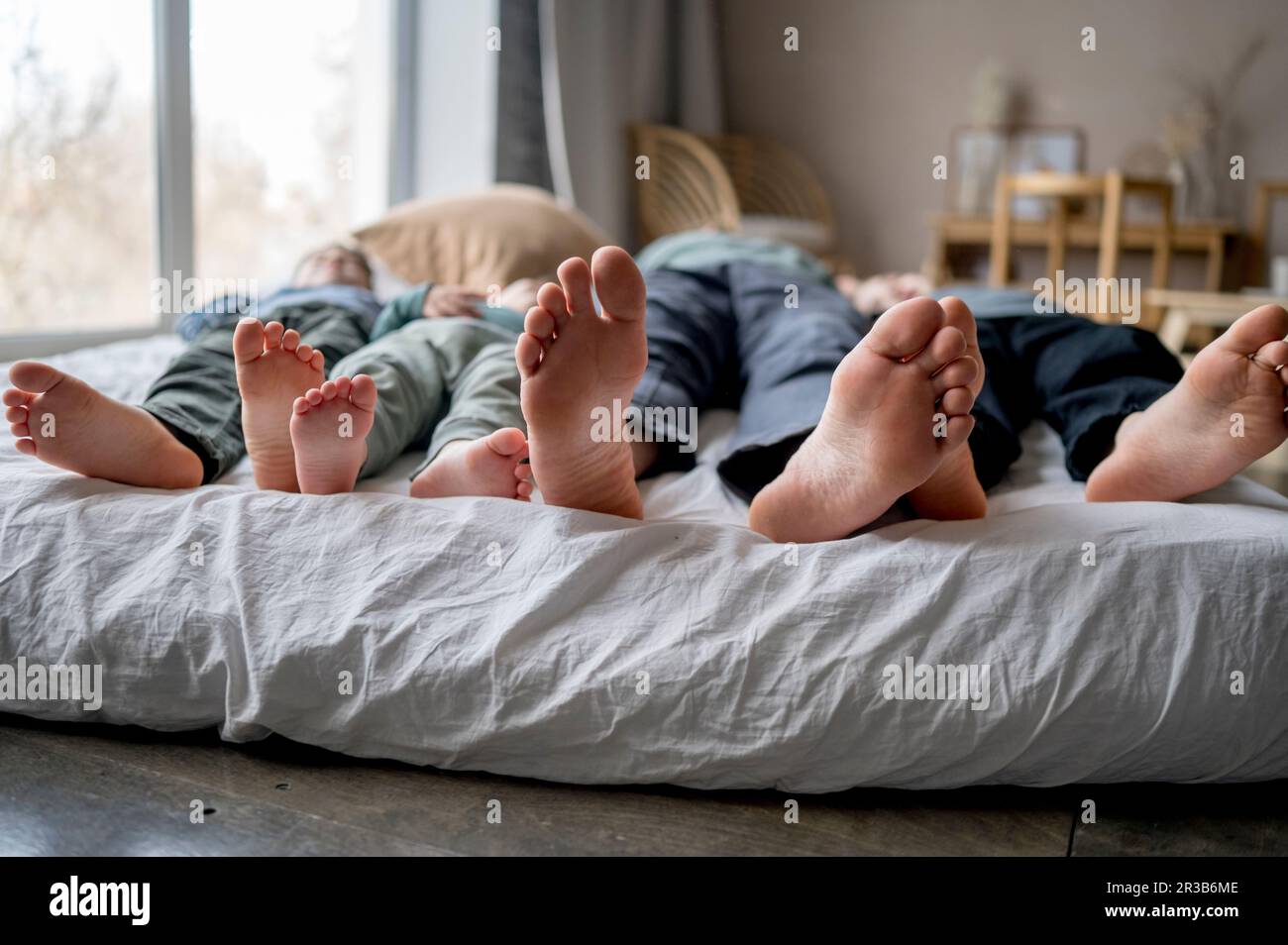 Il padre dorme con i figli a letto a casa Foto Stock