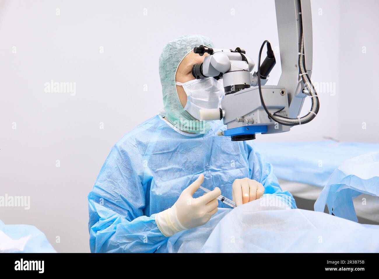 Chirurgo che esegue chirurgia oculare con microscopio Foto Stock