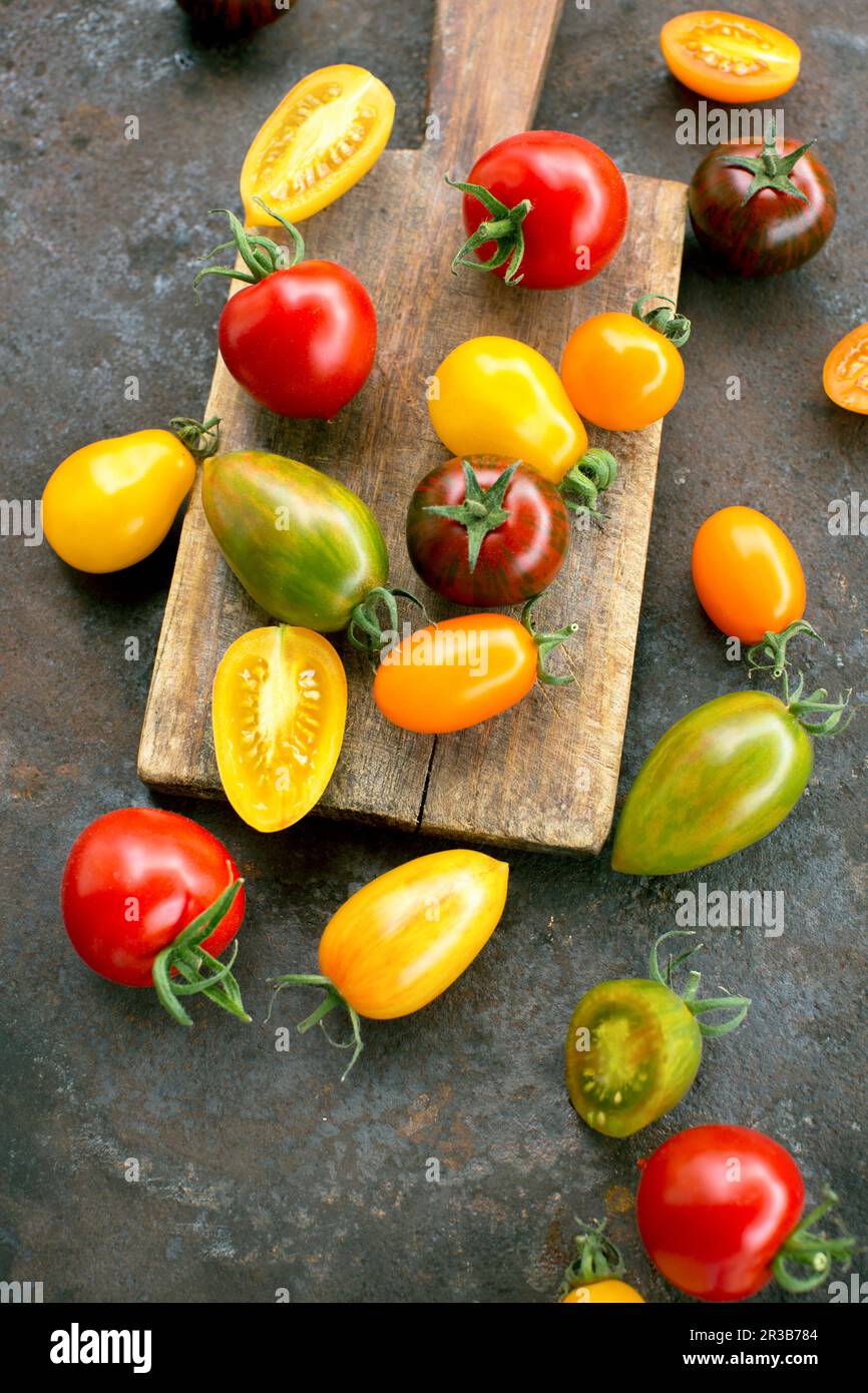 Pomodori colorati su una superficie rustica Foto Stock