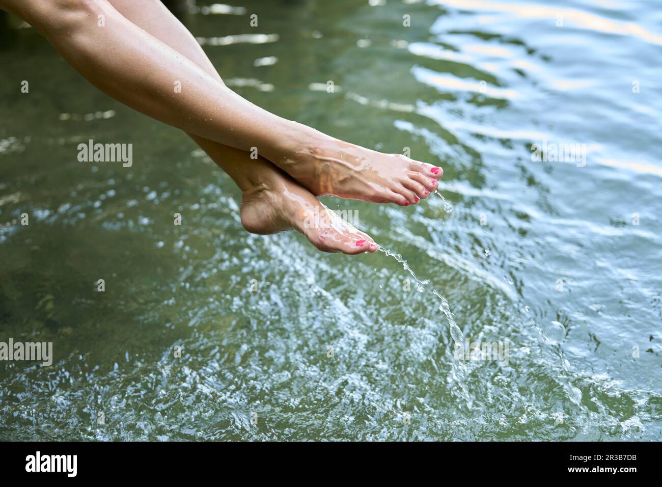 Donna con acqua a piedi nudi in lago Foto Stock