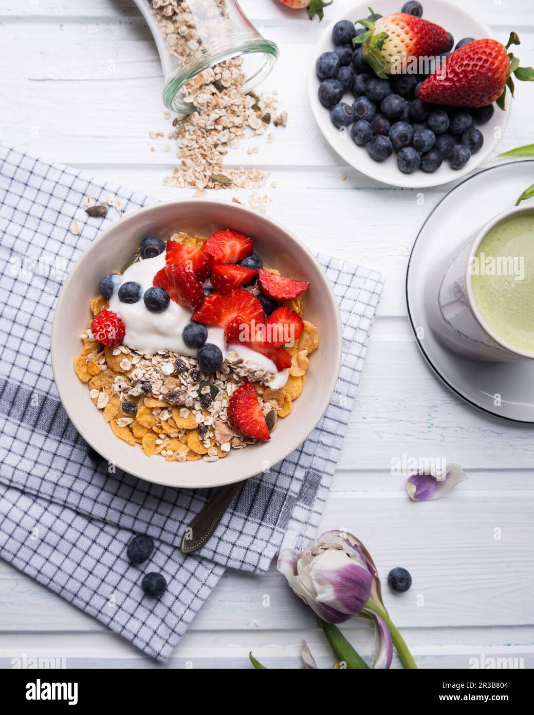 Muesli con yogurt alle mandorle e frutti di bosco freschi, con tè matcha Foto Stock