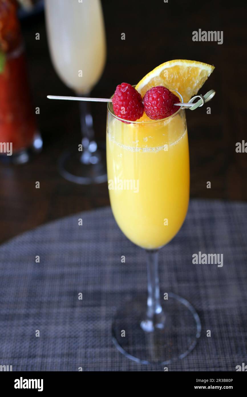Cocktail Mimosa con contorno di lamponi Foto Stock