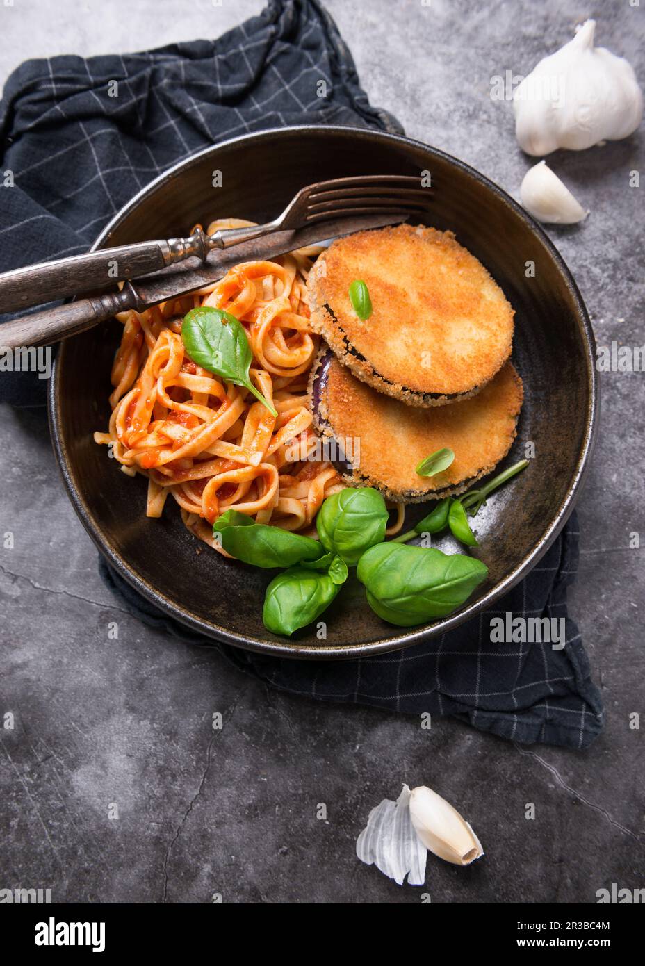 Cotolette di melanzane con tagliatelle a nastro in salsa di pomodoro Foto Stock