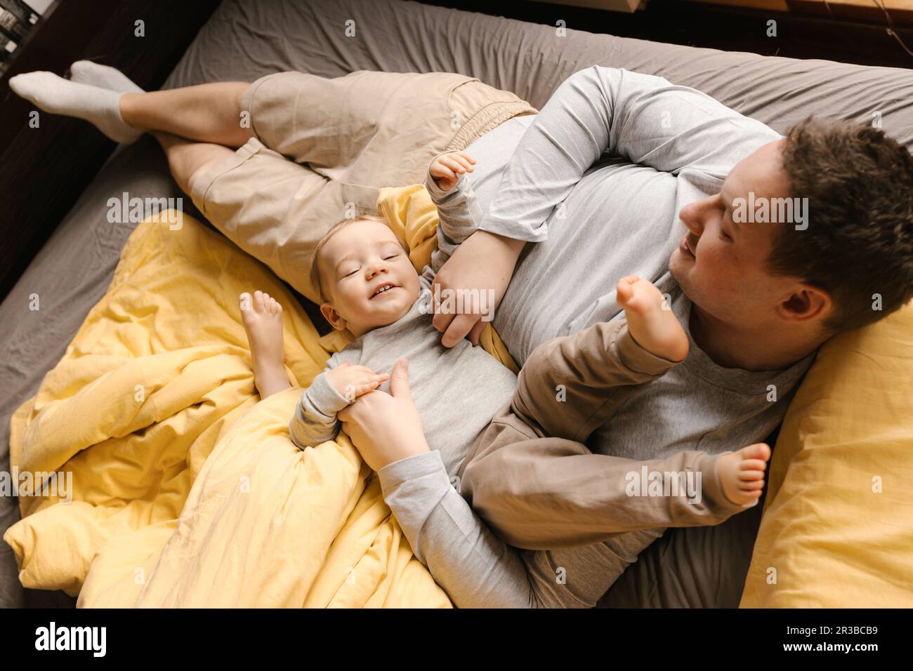 Padre che gioca con il figlio a letto a casa Foto Stock